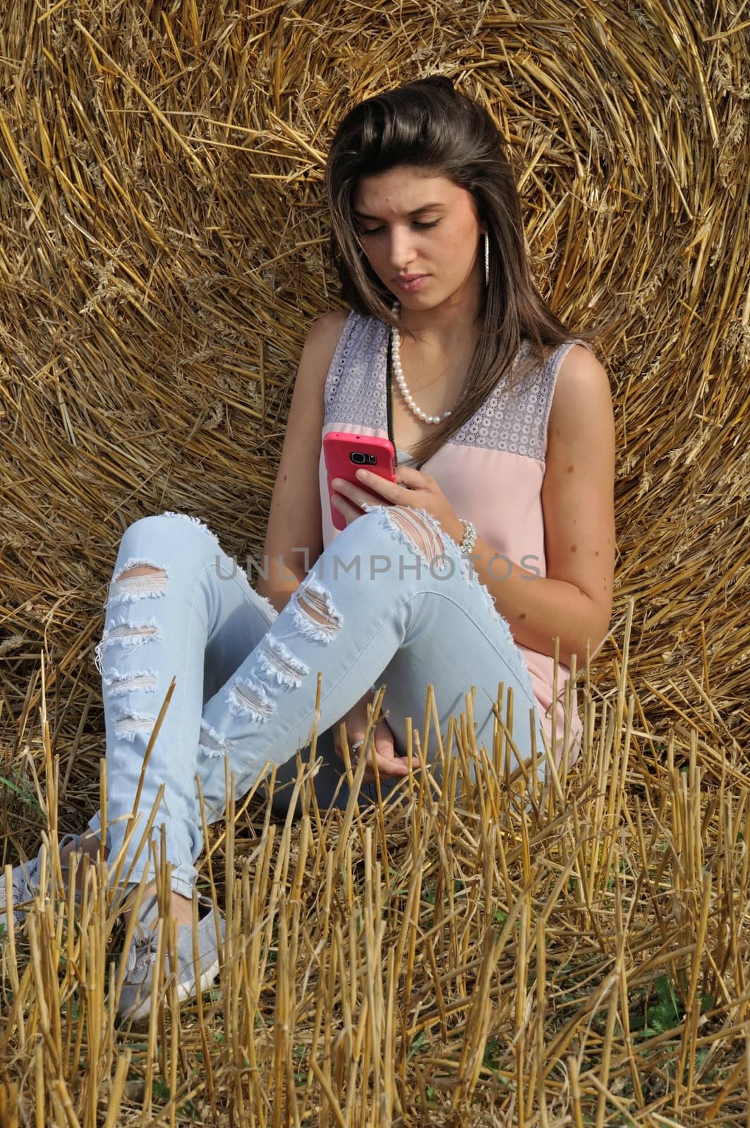 Young woman with her smartphone in field