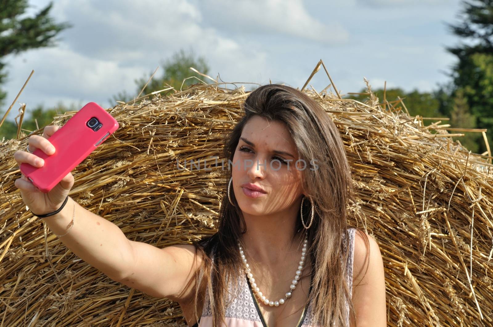 Young woman in field taking a selfie