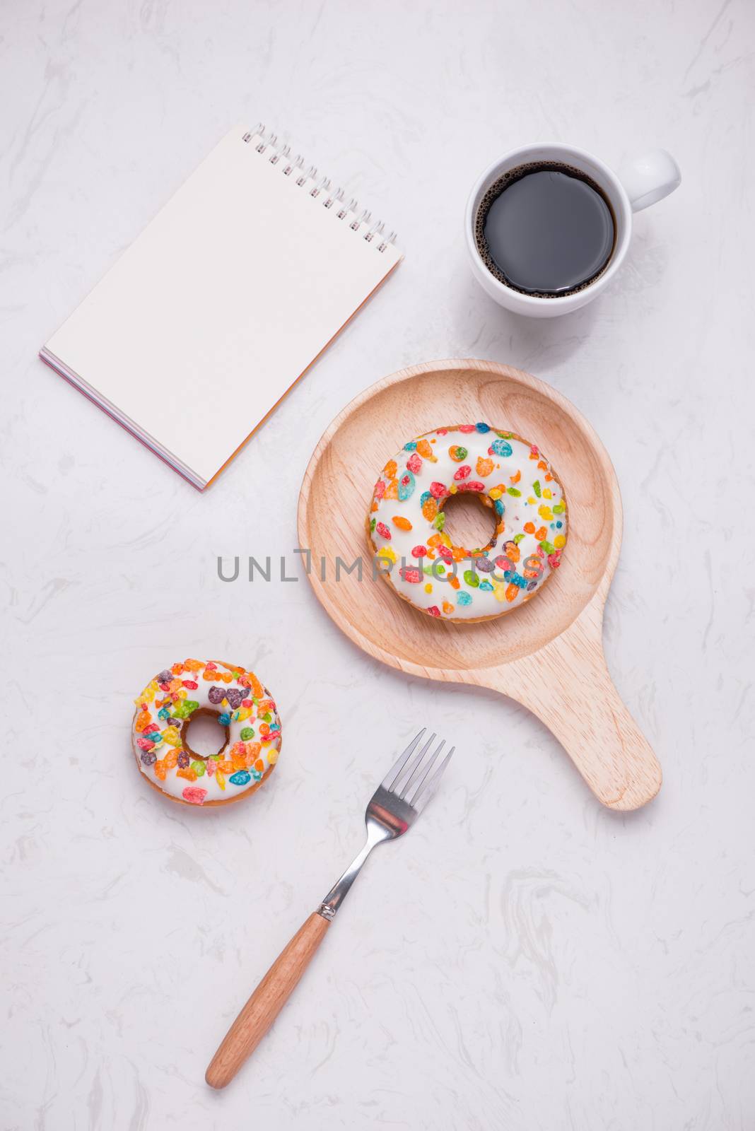 Working desk with dessert and coffee. Cake donuts with a cup of espresso on marble table top. 