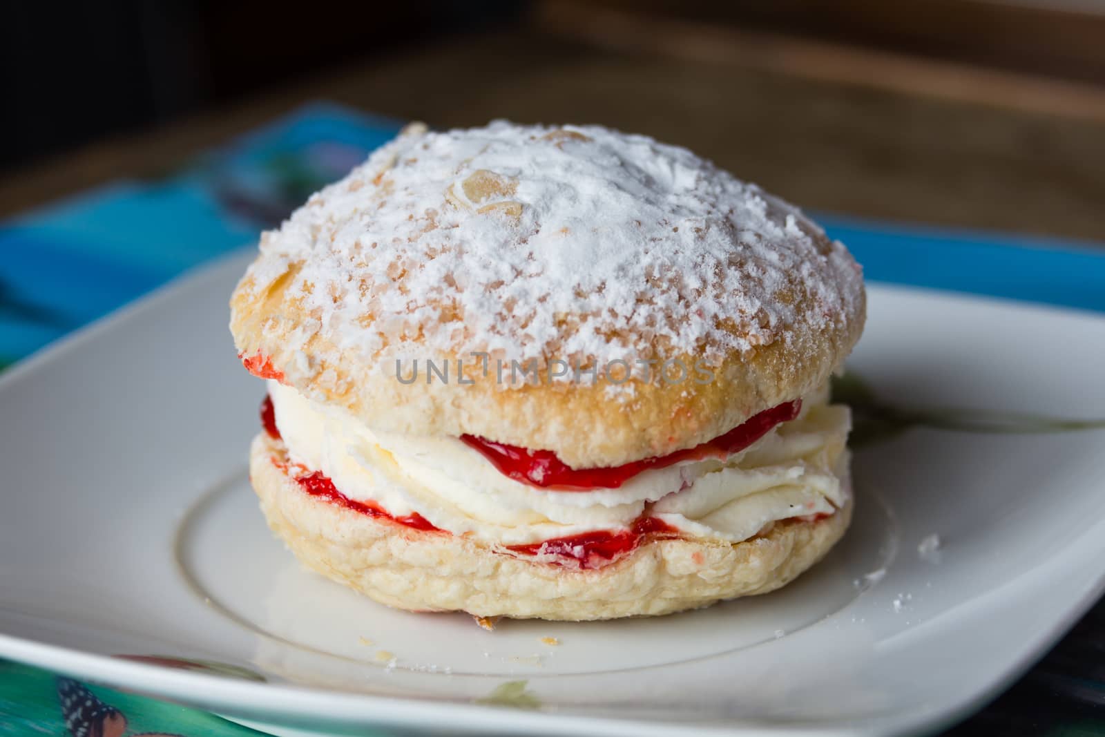 Bun of tender puff pastry with white custard and strawberry jam