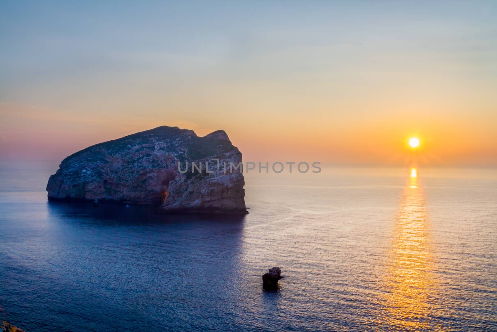 Sunrise and the small island in the sea by rainfallsup