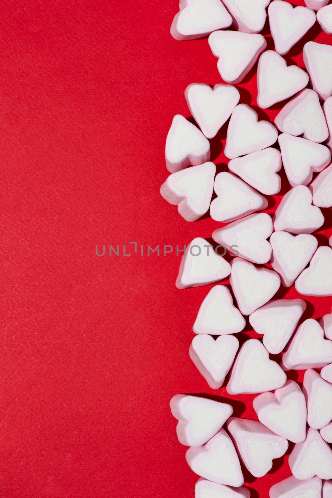 Valentines Day candy hearts marshmallows over red background by makidotvn