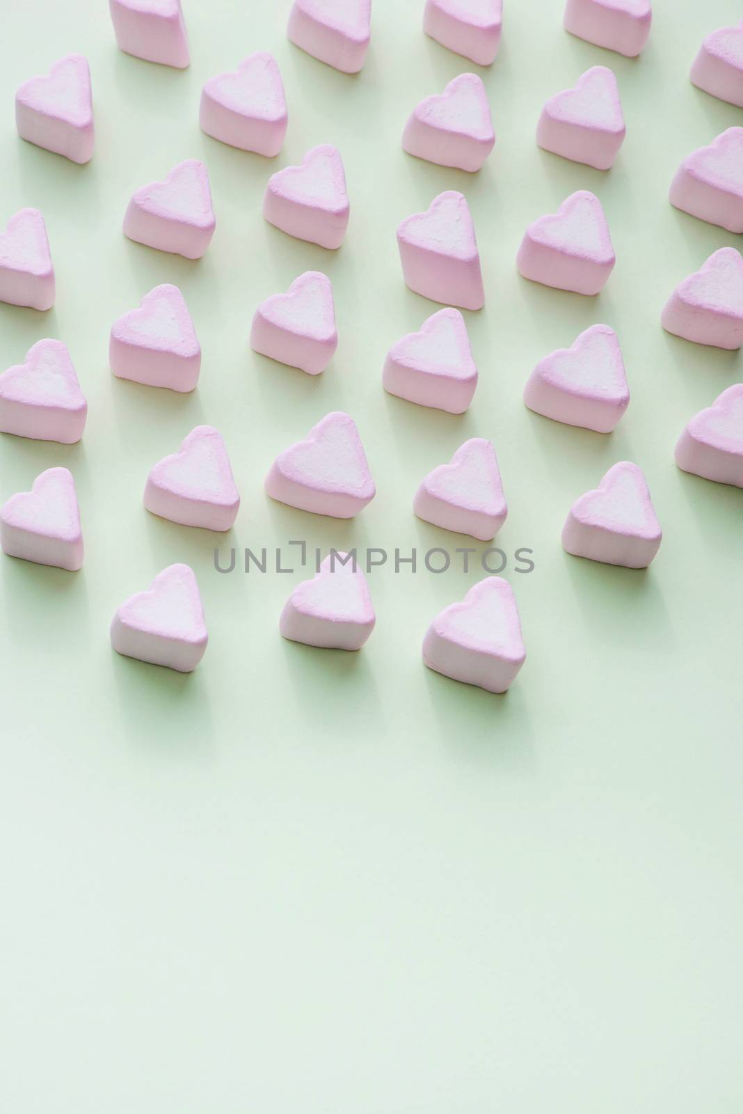 Valentines Day candy hearts marshmallows over green background by makidotvn