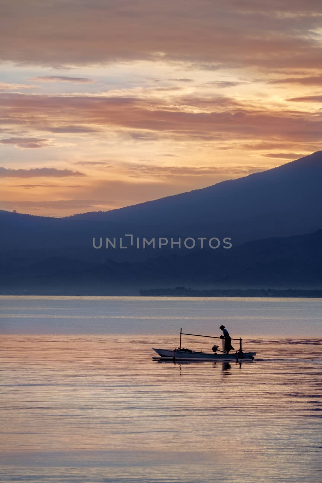 Oriental fisherman in the sea at sunrise