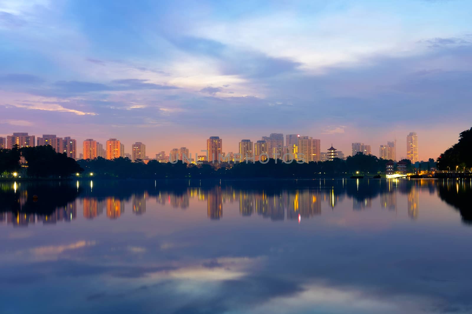 Reflection of building in the lake at sunrise at lakeside. Singapore