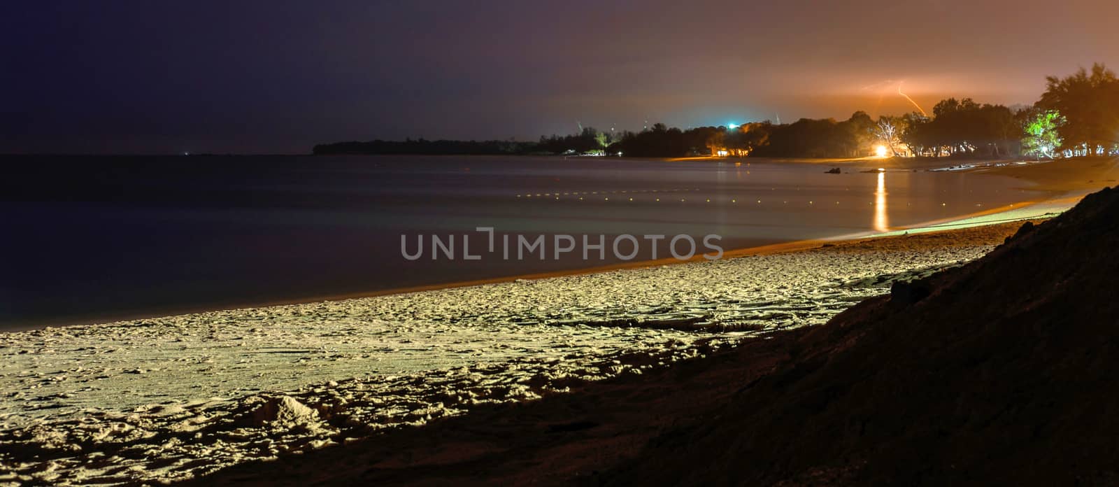 Desaru beach at night. Sea, sand and cloudy sky with bolt and thunder