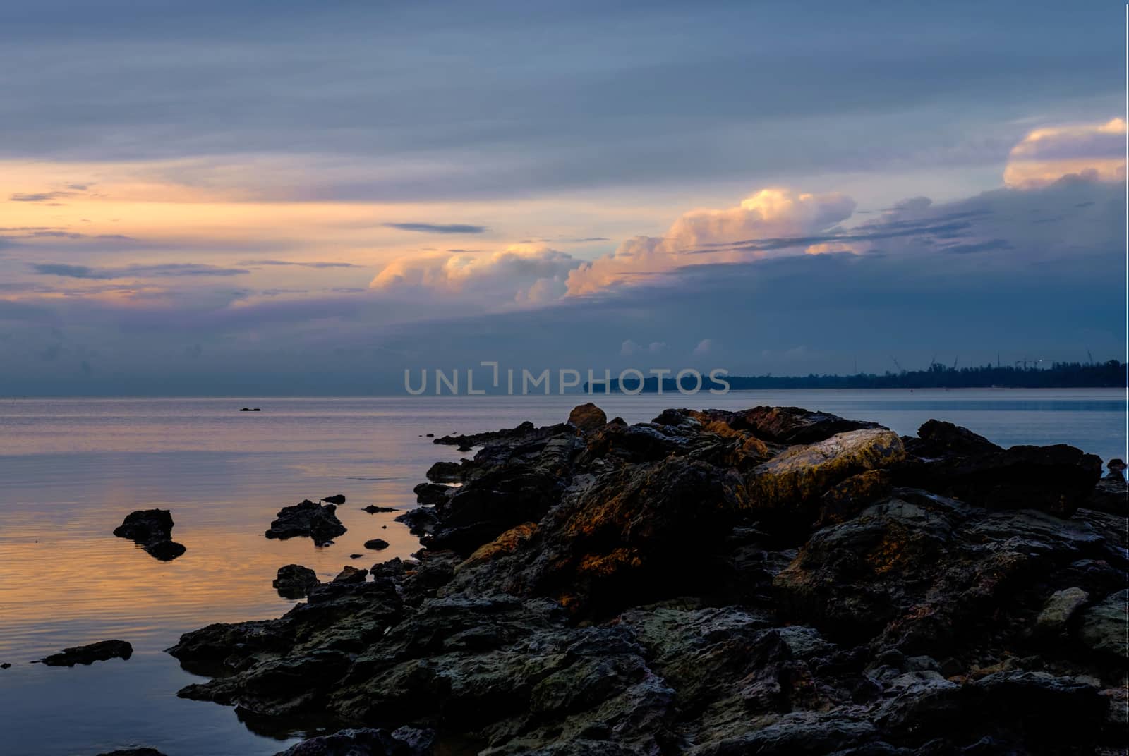 Stones in the sea at beautiful dusk sunrise by rainfallsup