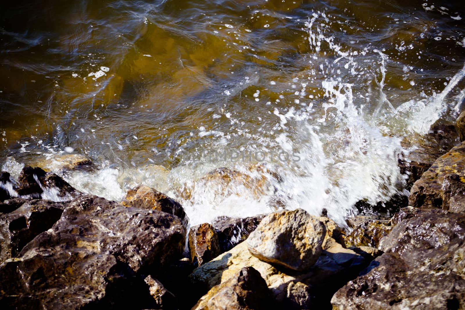 water wave breaks on the rocks