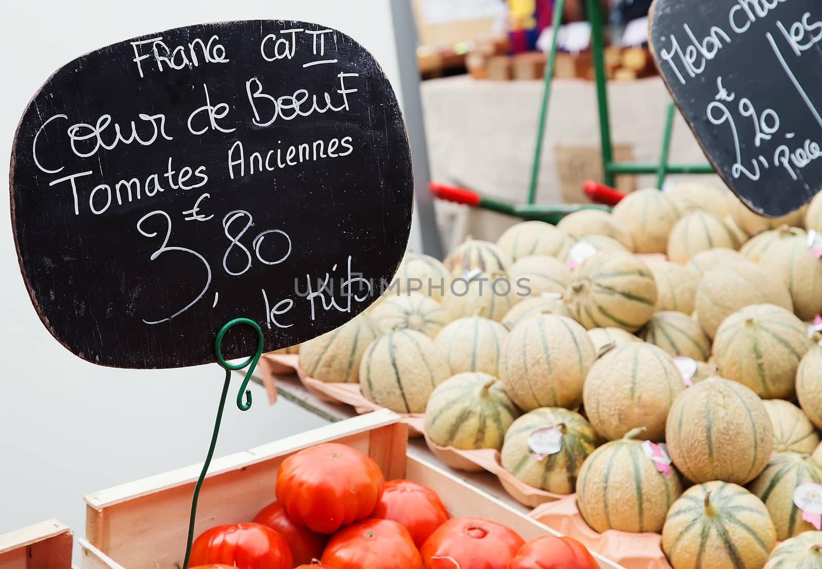 Beef heart tomatoes ("Tomates anciennes coeur de boeuf" in French) with melon on bakckground