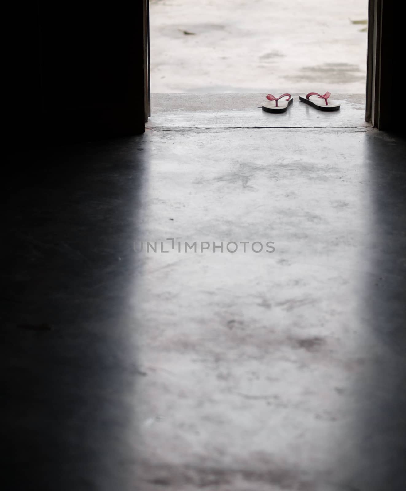 COLOR PHOTO OF PAIR OF FLIP FLOPS ON CONCRETE GROUND