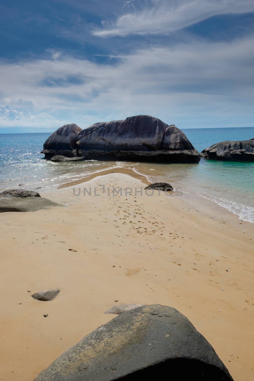 Tropical island sea shore with sand and rocks. Beautiful sunny day