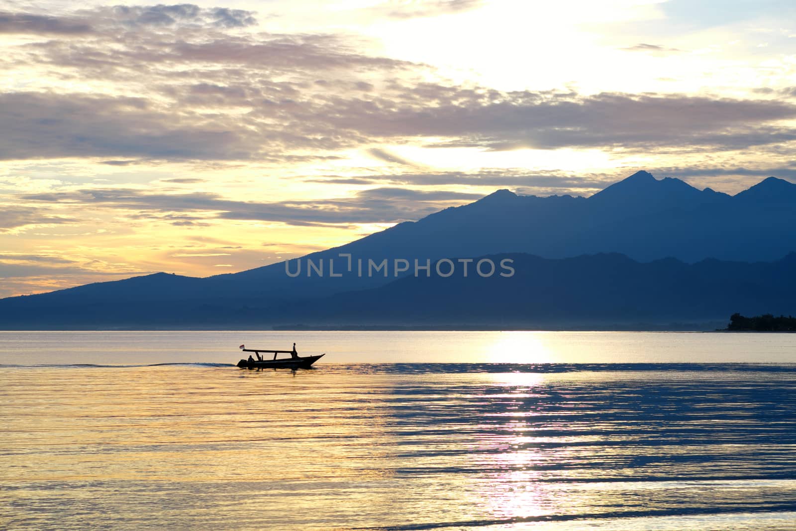 Boat with lombok volcano Rinjani in the background before the sunrise by rainfallsup