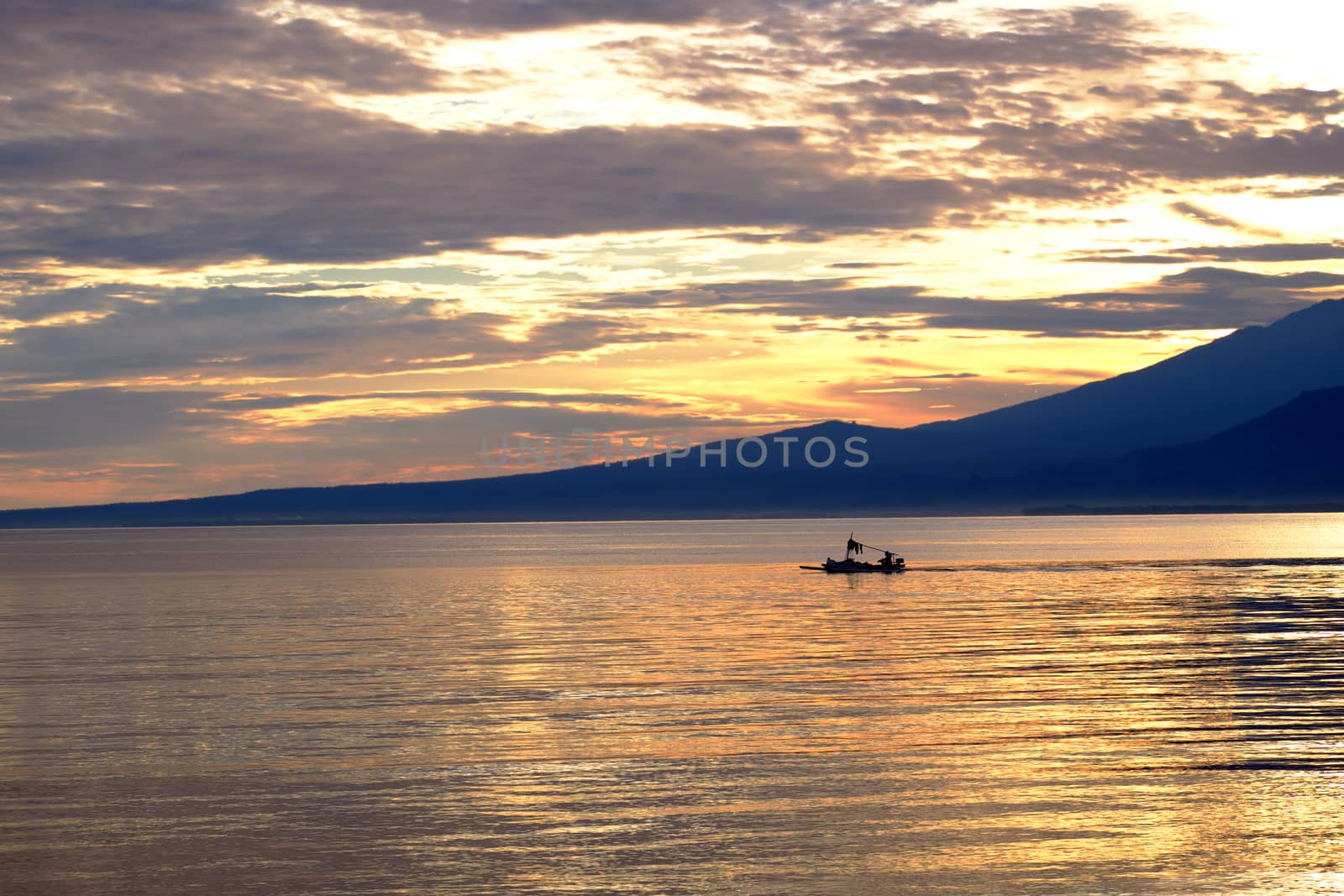 Fisherman boat with lombok volcano Rinjani in the background before the sunrise by rainfallsup