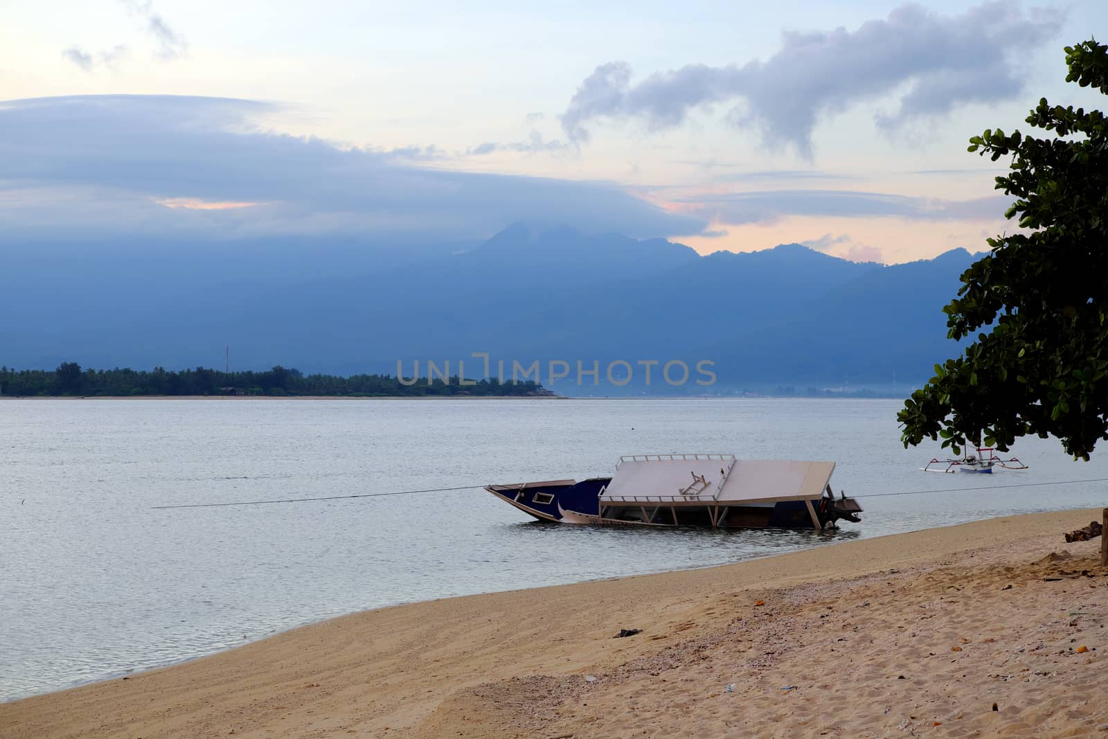 Drowned boat near gili meno, indonesia in the early morning before the sunrise by rainfallsup