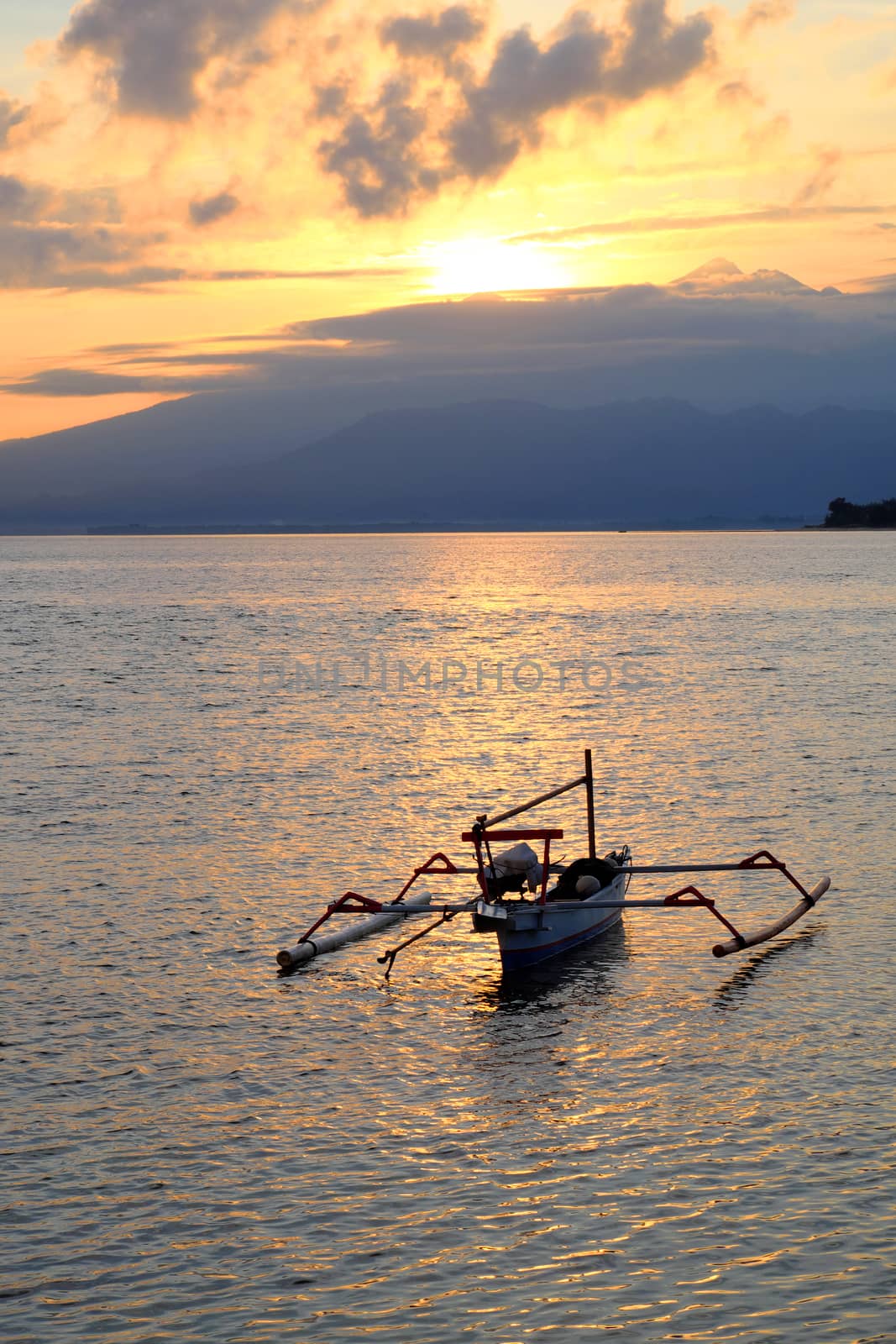 Catamaran boat at the sunrise in indonesia with lombok volcano Rinjani in the background by rainfallsup