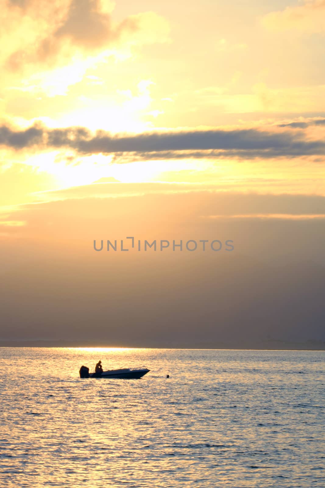 Boat with snorkelers at the sunrise at the sea