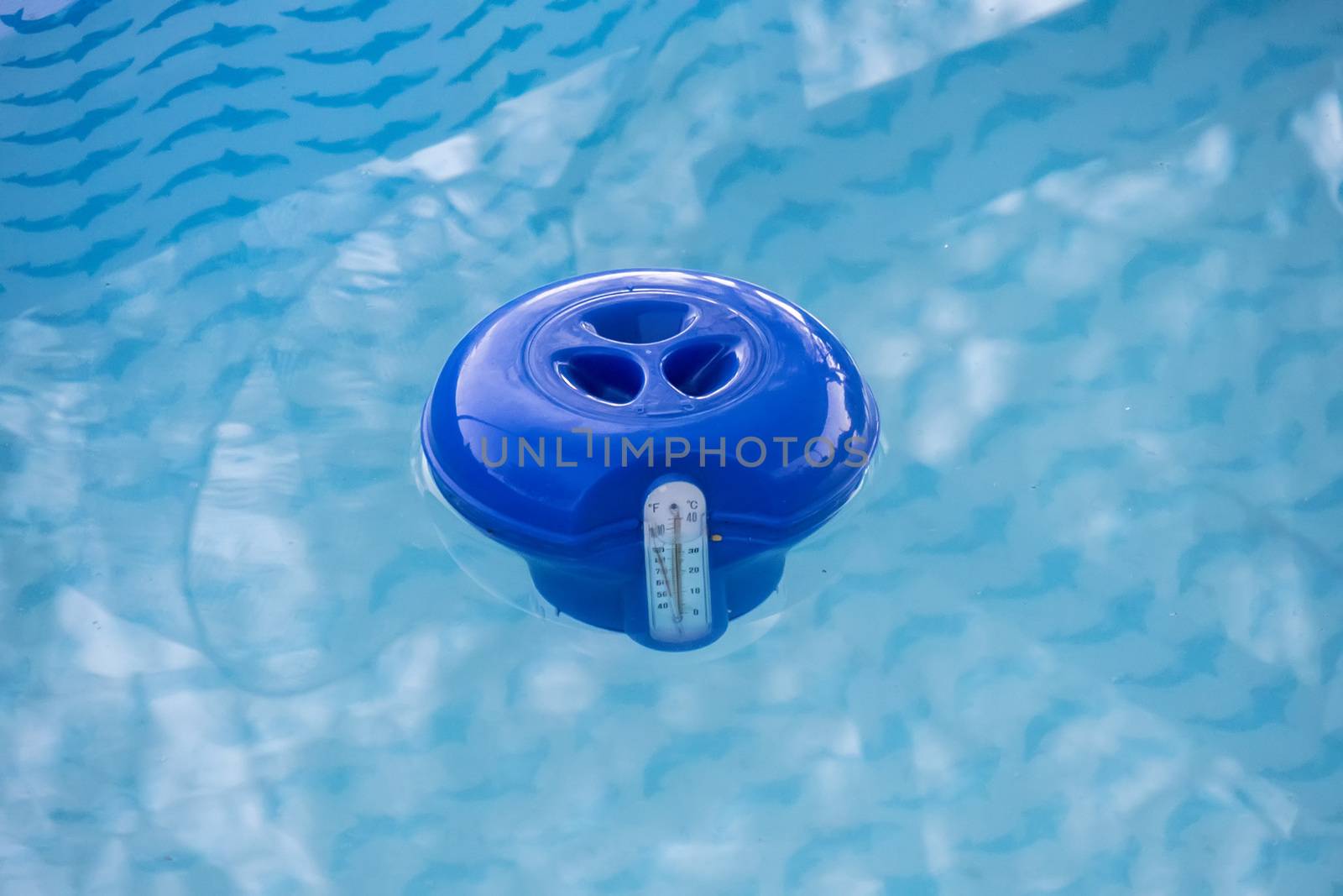 Blue pool chlorine dispenser in the water