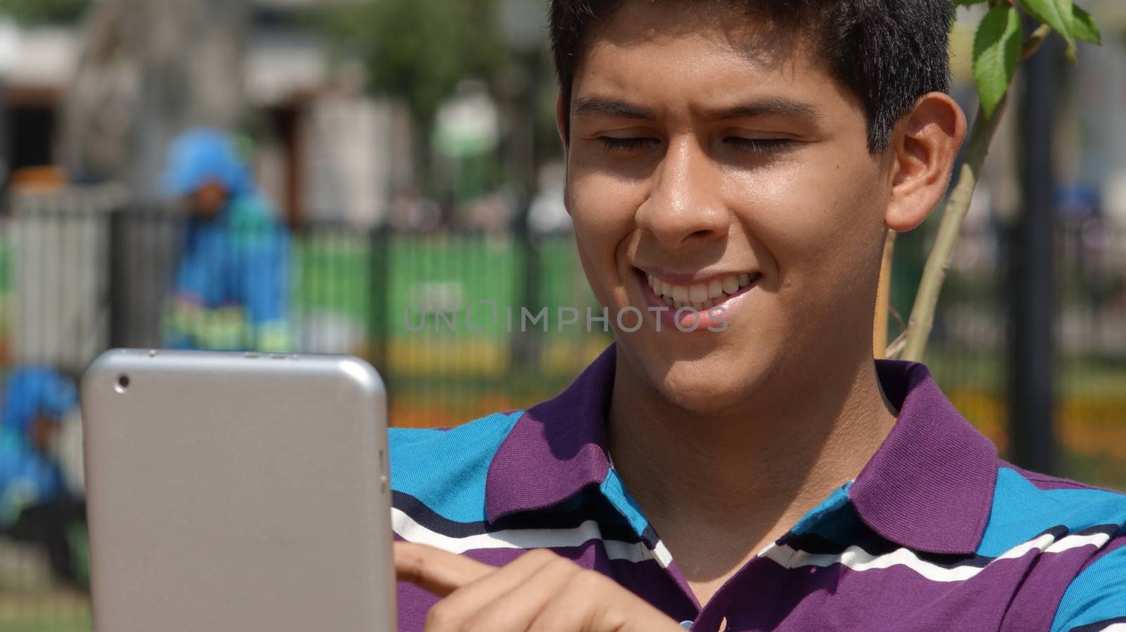 Happy Teen Boy Using Tablet by dtiberio