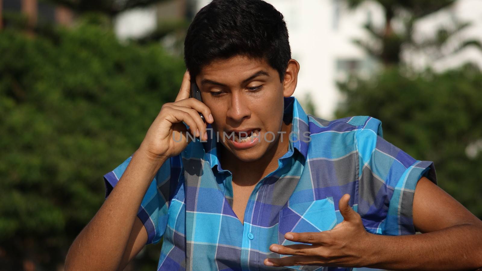 Angry Teen Boy Talking On Cell Phone by dtiberio