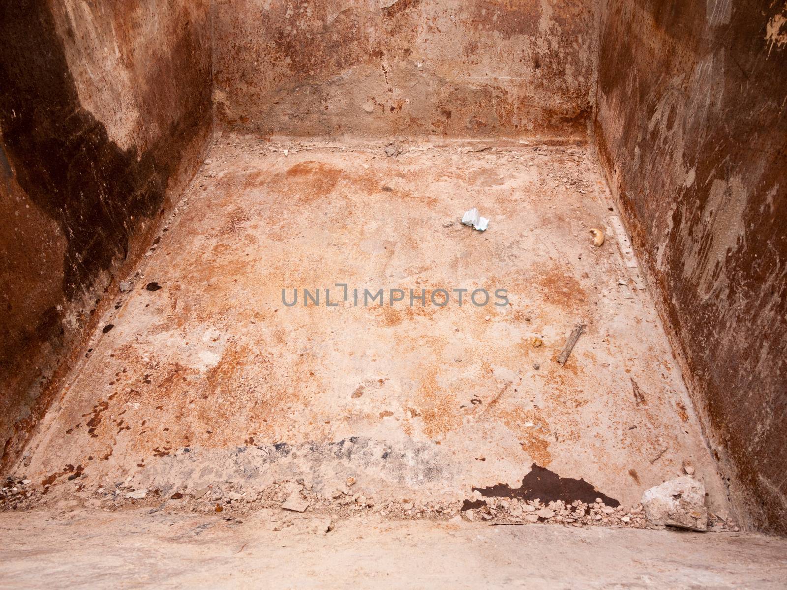 the grimy and textured rough inside of a skip outside with nothing no items inside empty bits and crumbs of dirt and rubble