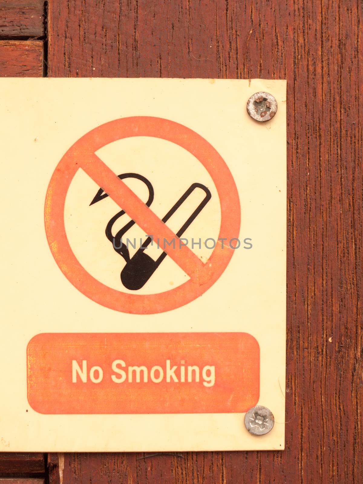 a nailed and screwed down sign red and black and white saying no smoking with a circle crossed of a cig cigarette no allowed safety health private restrictions law safety