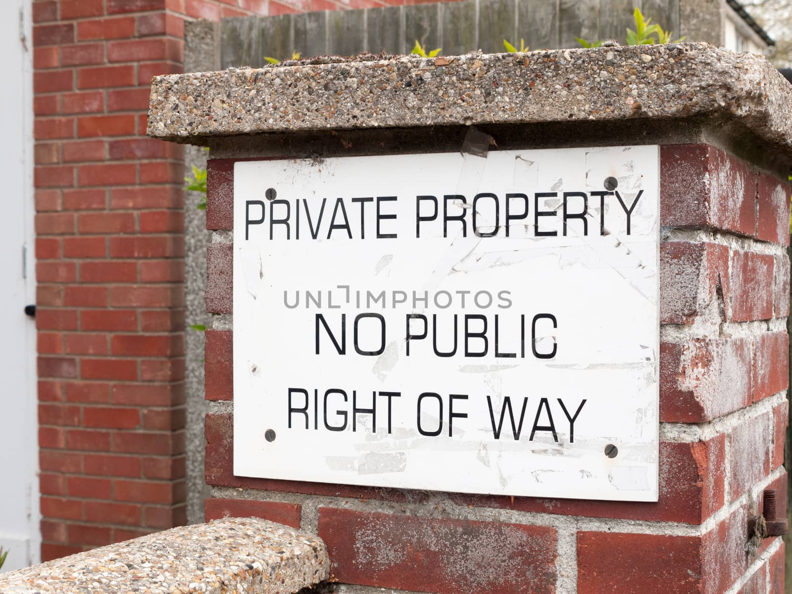 a public sign outside on a brick wall saying private property no public way of right white and back council law