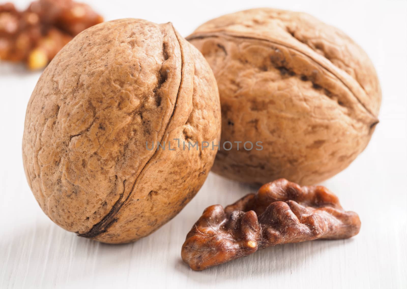 Close up view on inshell walnut on white wooden background