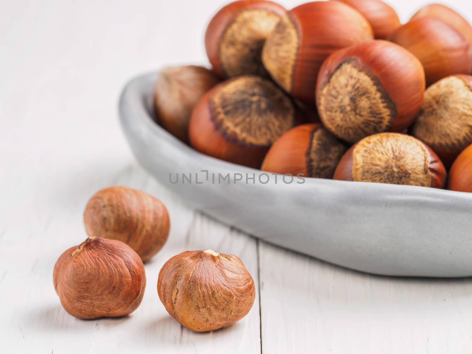 Close up view on hazelnut on white wooden background with copy space