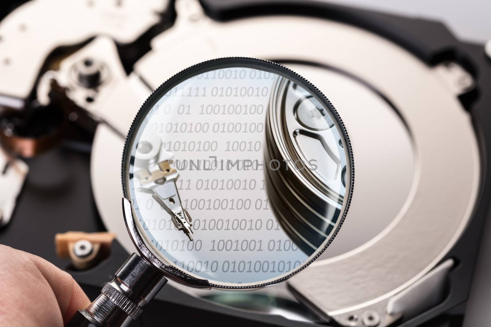 Disassembled computer hard disk and magnifier close-up