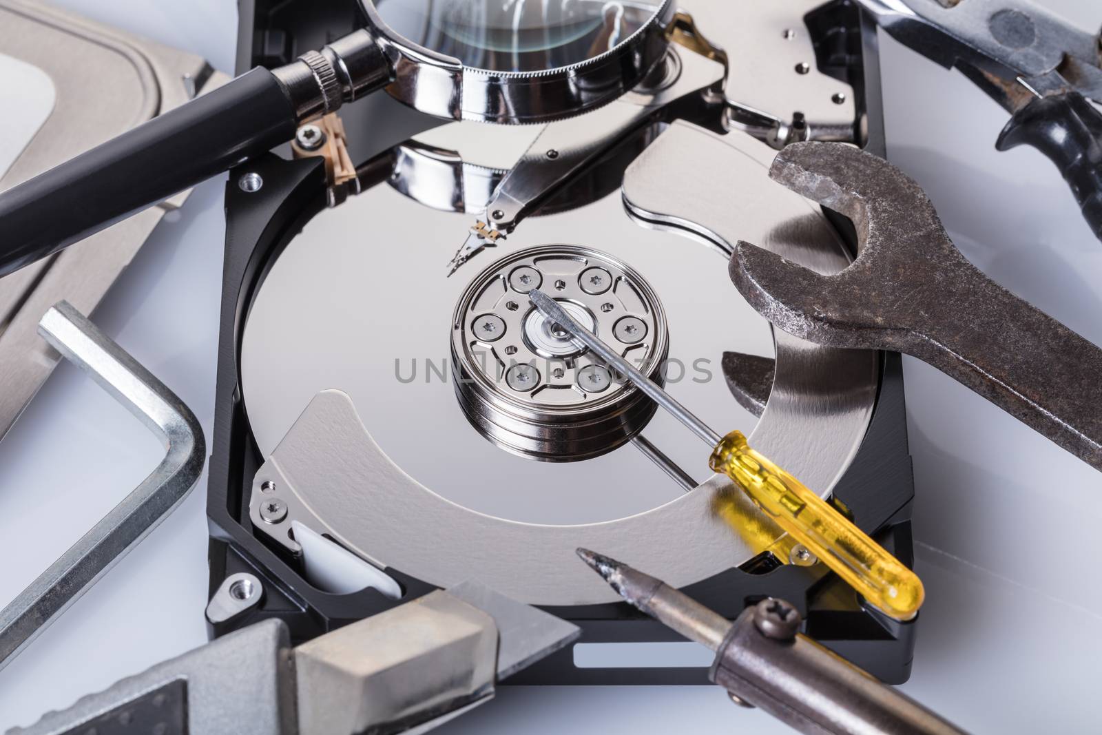 Disassembled computer hard disk and tools close-up