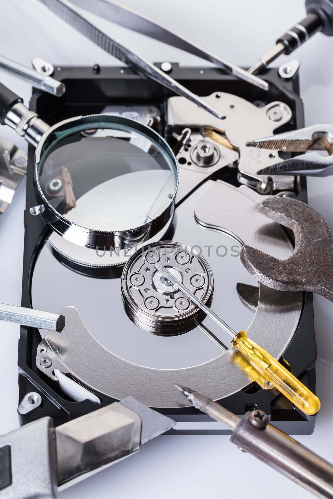Disassembled computer hard disk and tools close-up