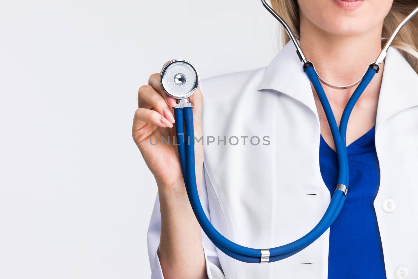 Female doctor holding stethoscope, light gray background with copy space