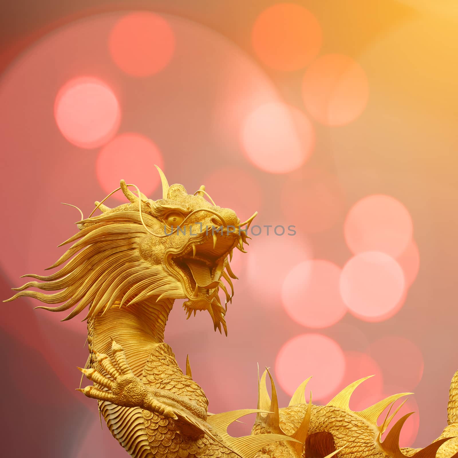 Golden chinese dragon statue with blurry bokeh background.