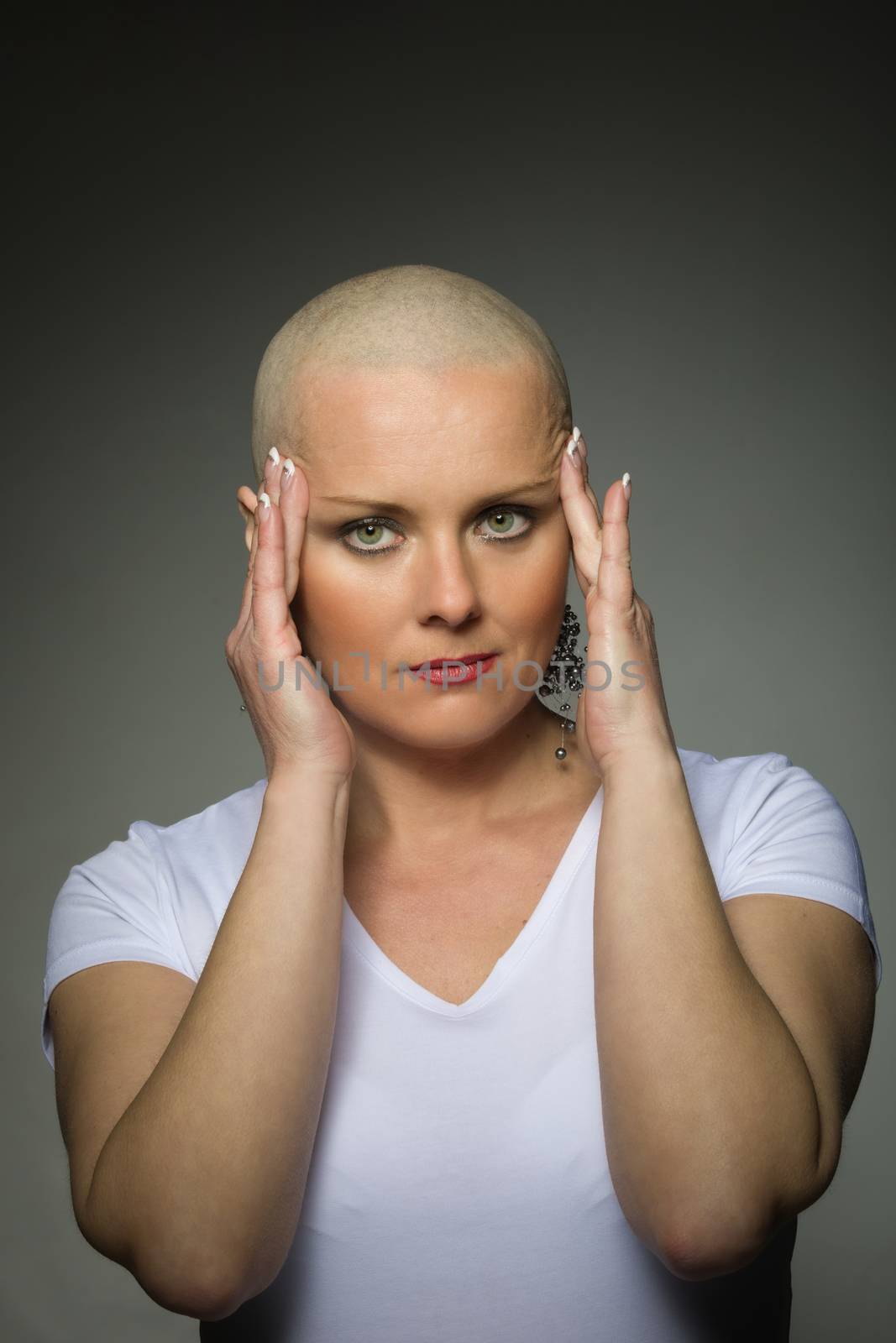 Portrait of beautiful middle age woman patient with cancer with shaved head without hair, hope in healing. Hand on head. She lost her hair