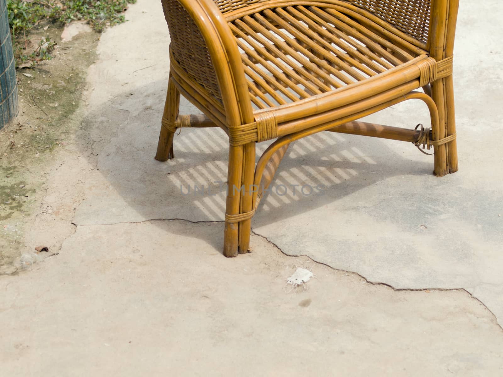 COLOR PHOTO OF RATTAN CHAIR ON CONCRETE GROUND