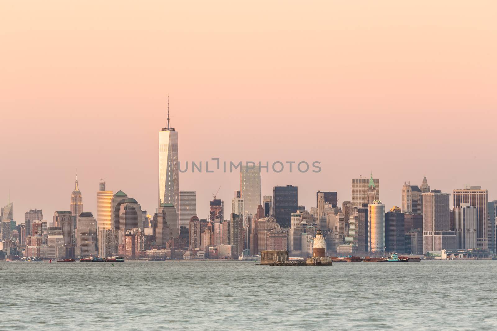 New York City Manhattan downtown skyline at dusk with skyscrapers illuminated over Hudson River panorama. Horizontal composition, copy space.