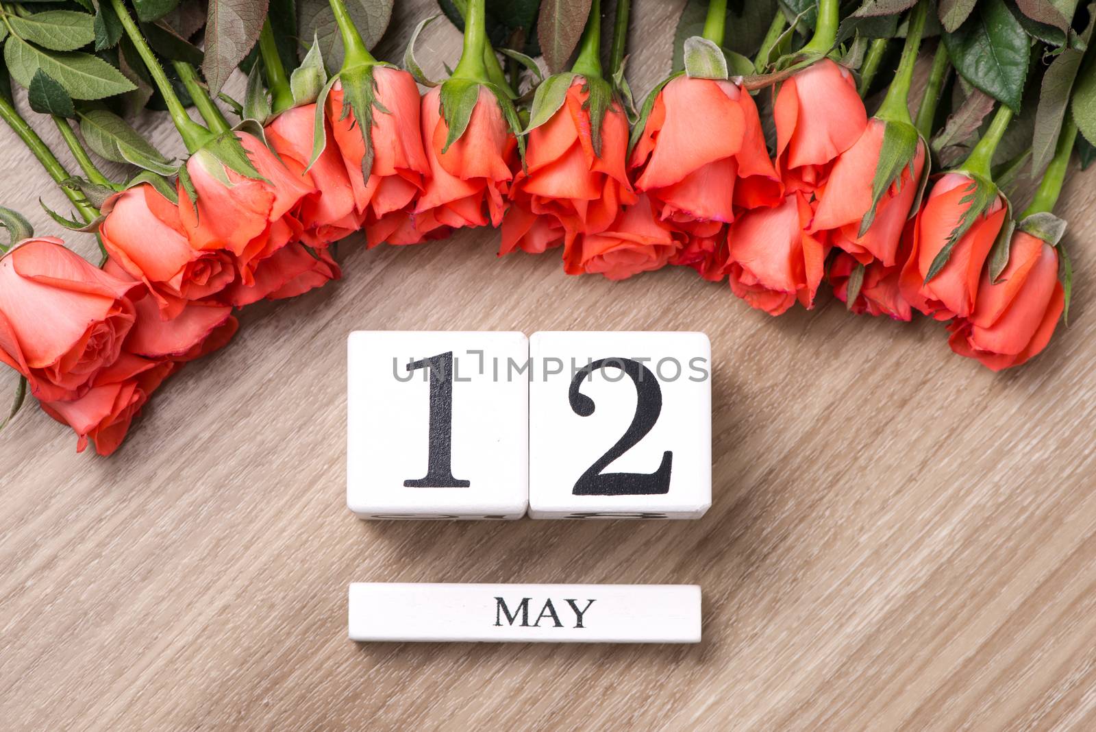 Cube shape calendar for MAY 12 on wooden table with roses by makidotvn