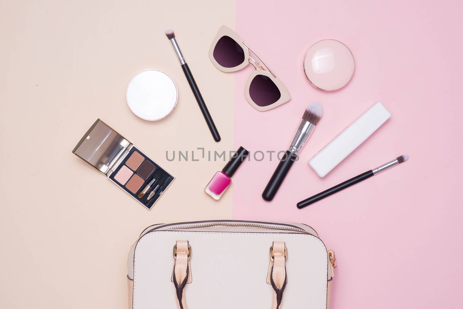 Flat lay of female fashion accessories and white handbag on past by makidotvn