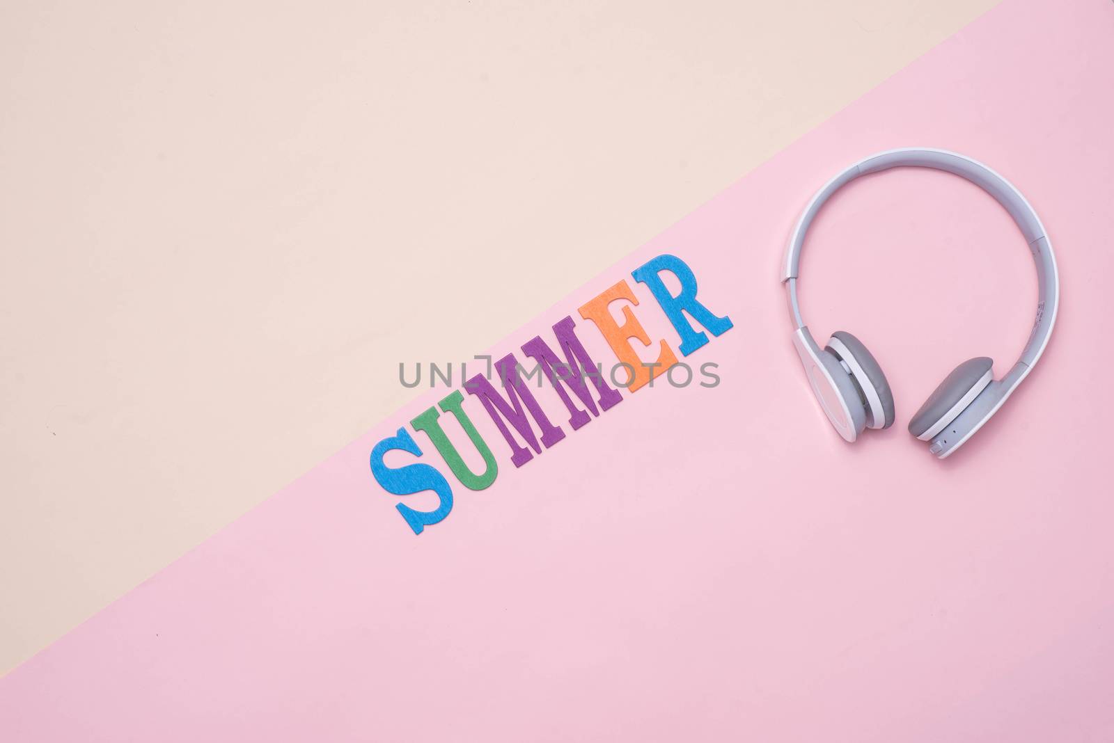 Summer fun written in colorful wooden letters on pastel color ba by makidotvn