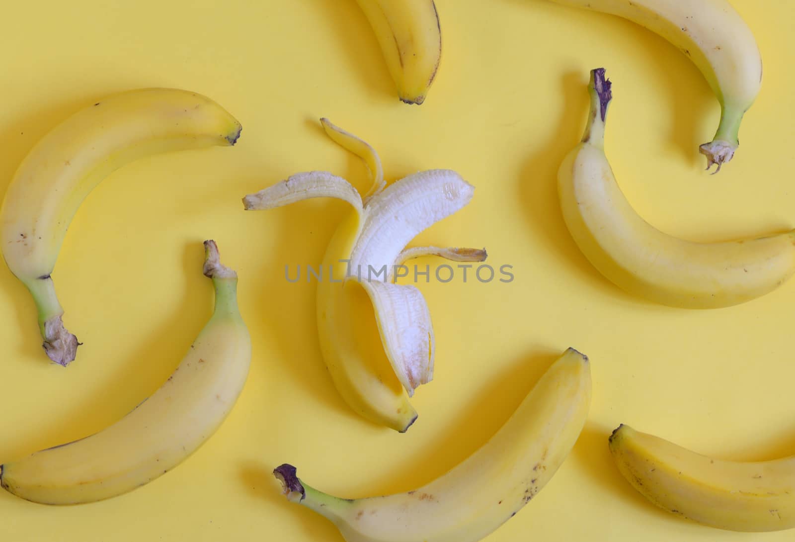 Ripe bananas set on yellow background