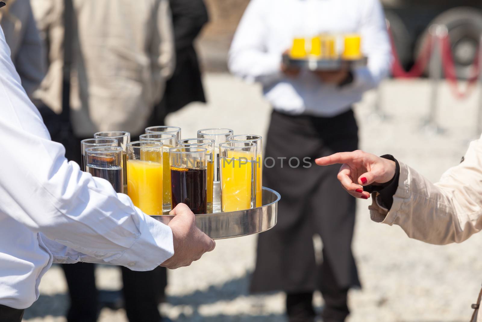 Waiter serving soft drinks at a party by wellphoto