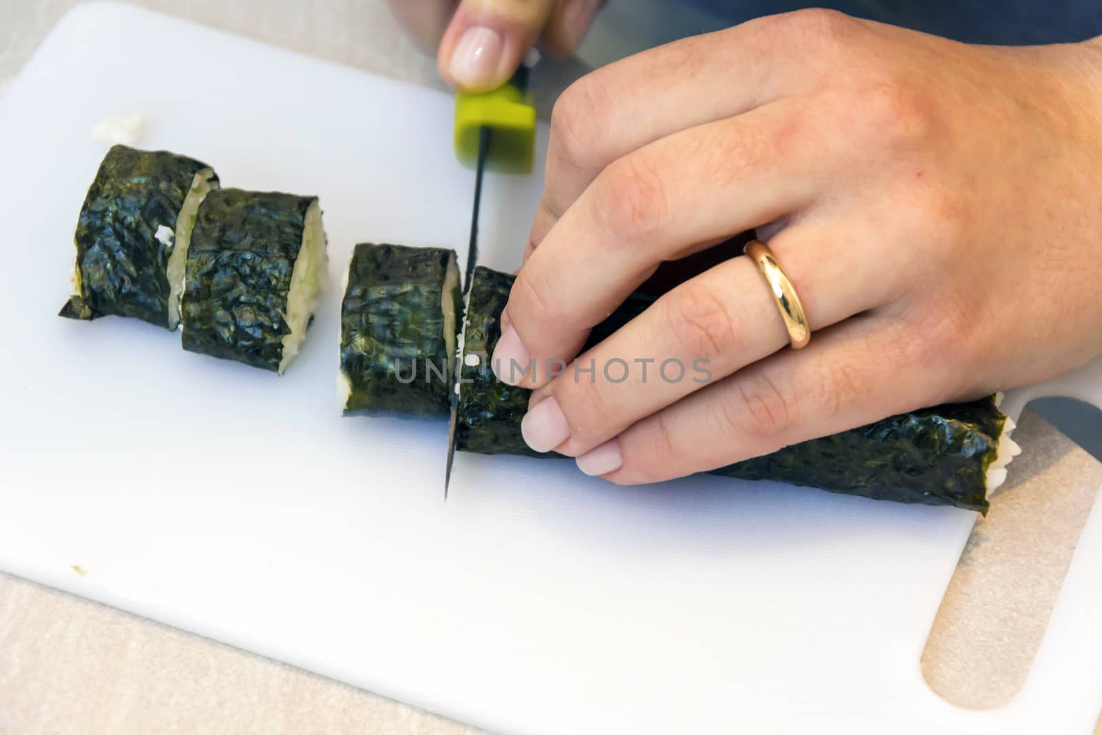 Slicing sushi rolls at home on a cutting board