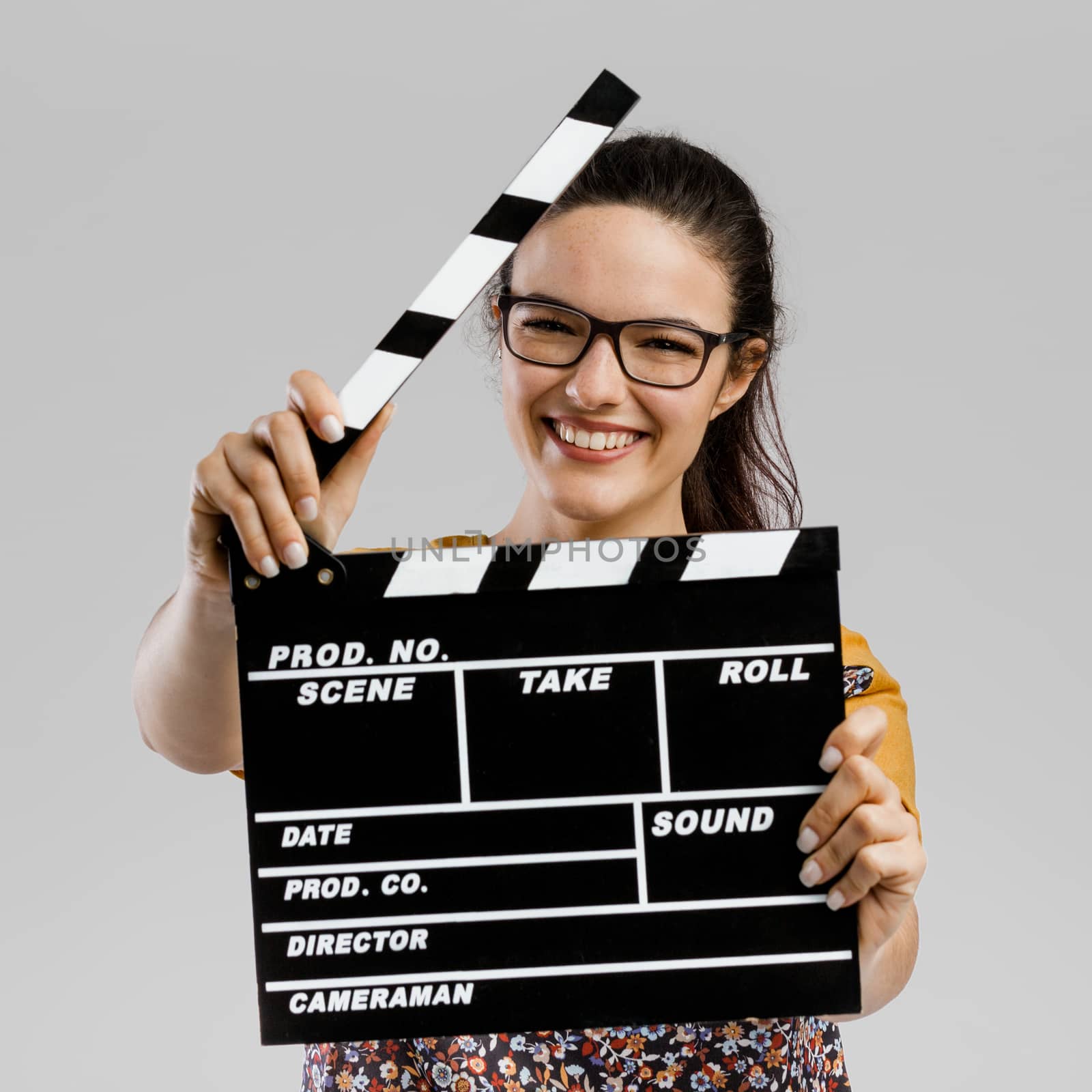 Portrait of beautilful woman holding a clapboard