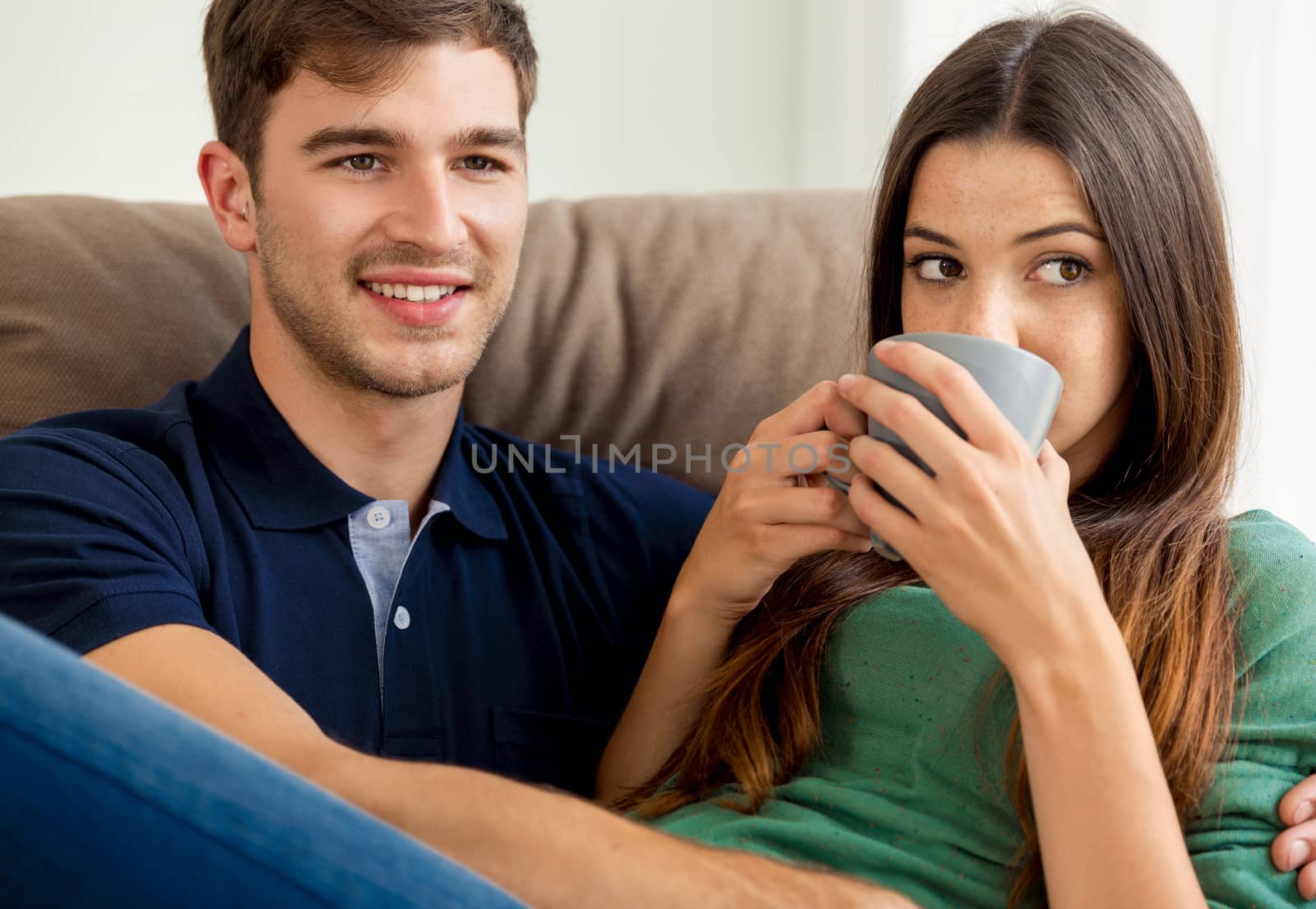 Young couple on the sofa drinking coffee