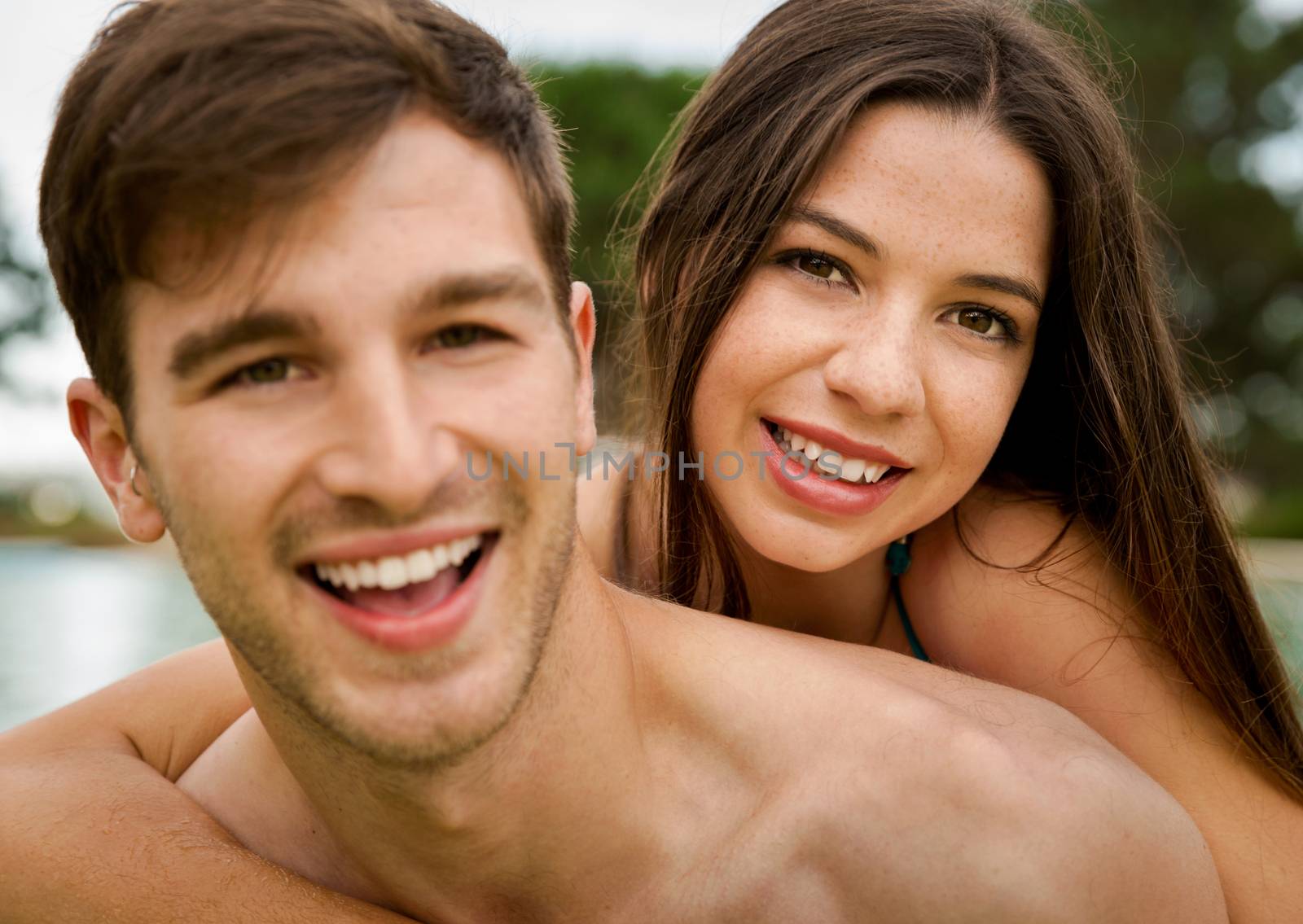 Portrait of a young couple embraced inside the pool