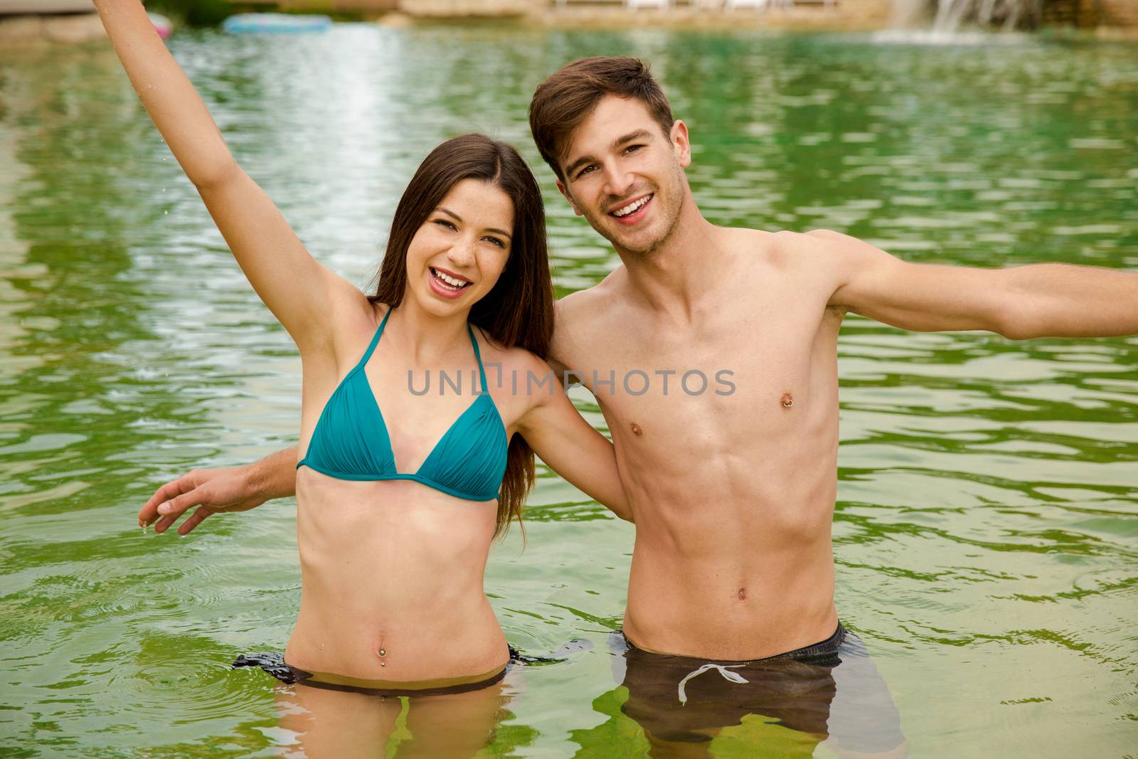 Young couple inside the pool and having fun