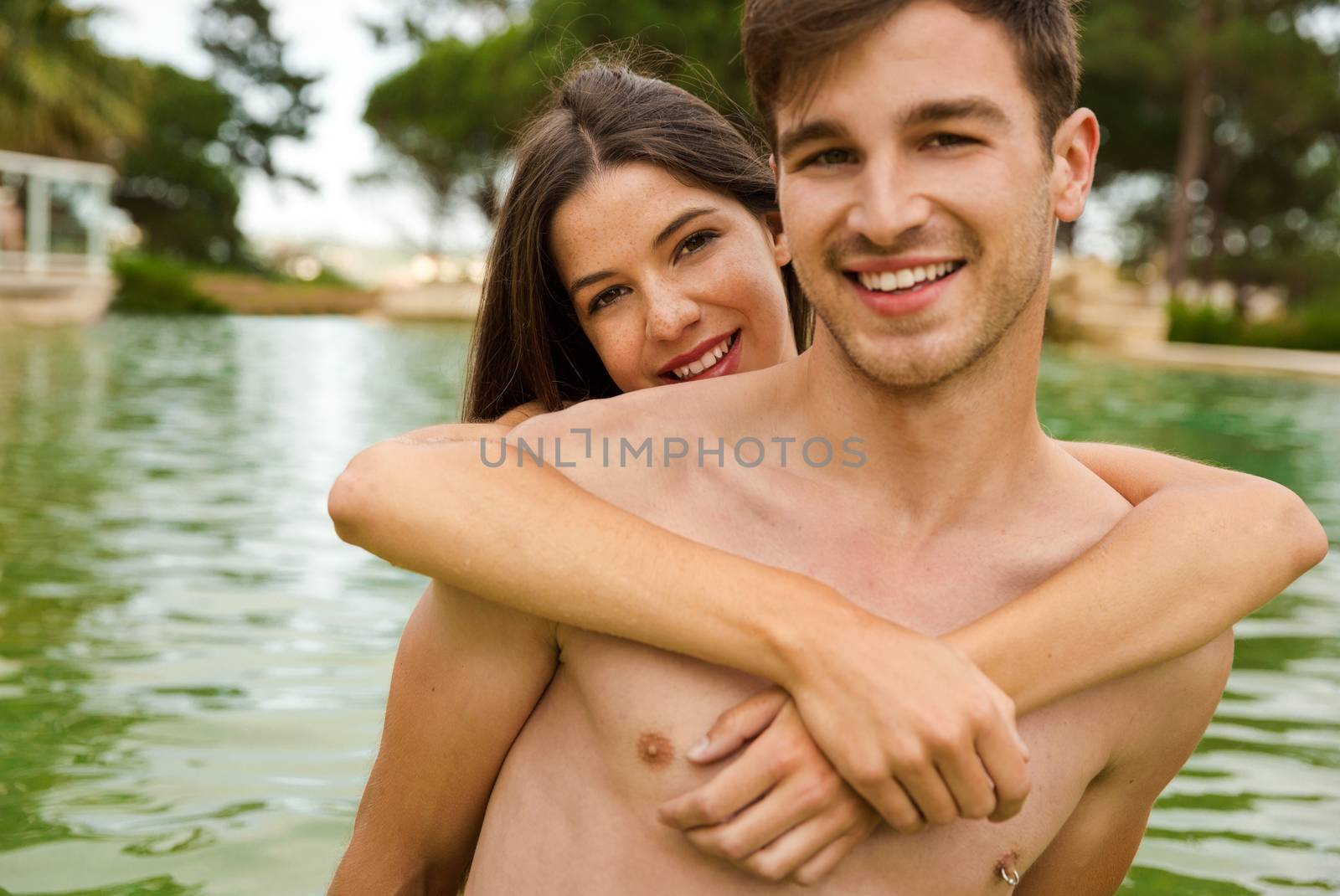 Portrait of a young couple embraced inside the pool