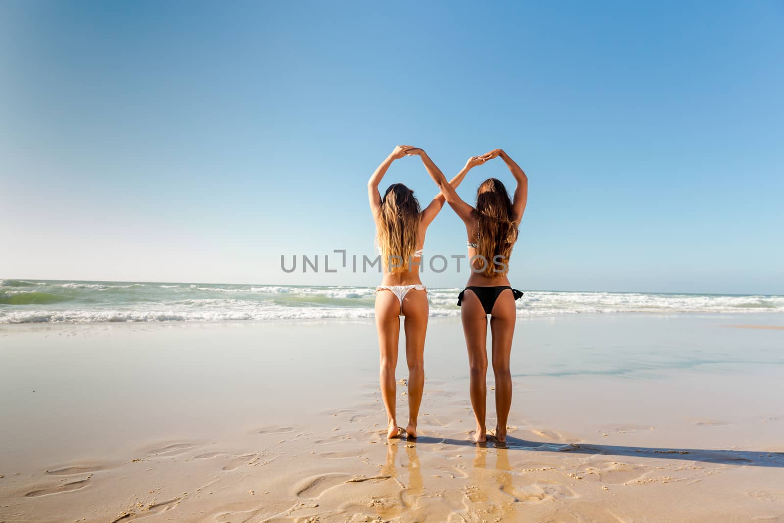 Beautiful girls in the beach giving her hands together