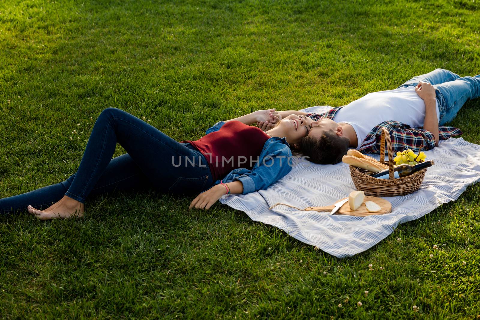 Happy young couple in the park relaxing after the picnic