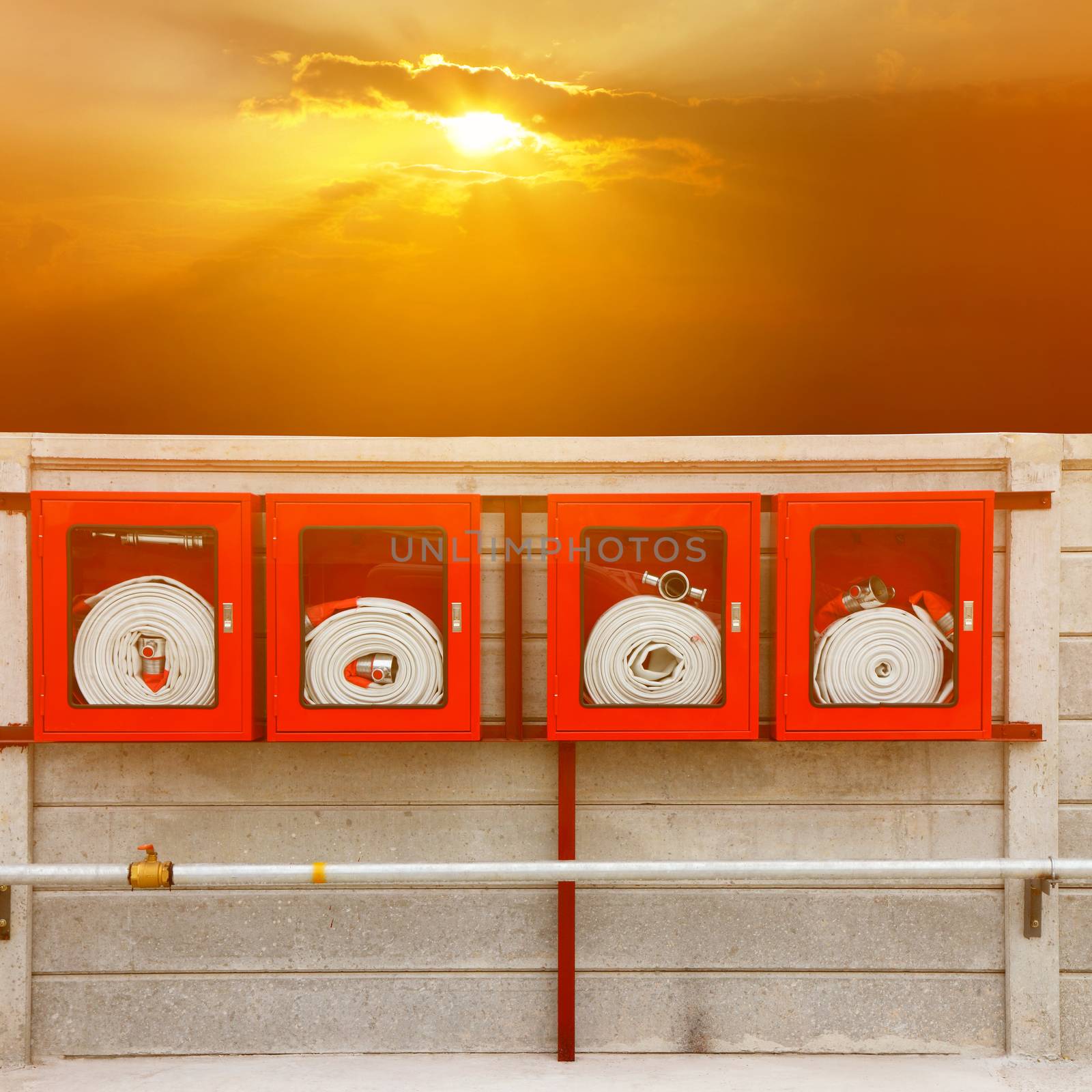 Fire extinguisher equipment on the wall (fire, protection, system) with sunray background.